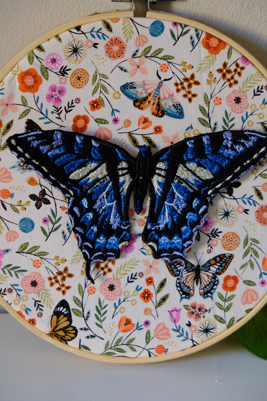 Telaio tondo in stoffa con applicata farfalla blu