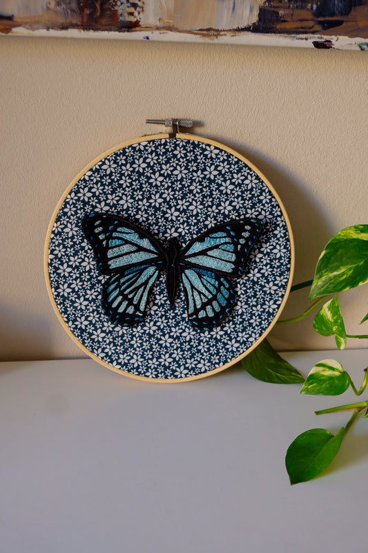 Telaio tondo in stoffa con applicata farfalla azzurra